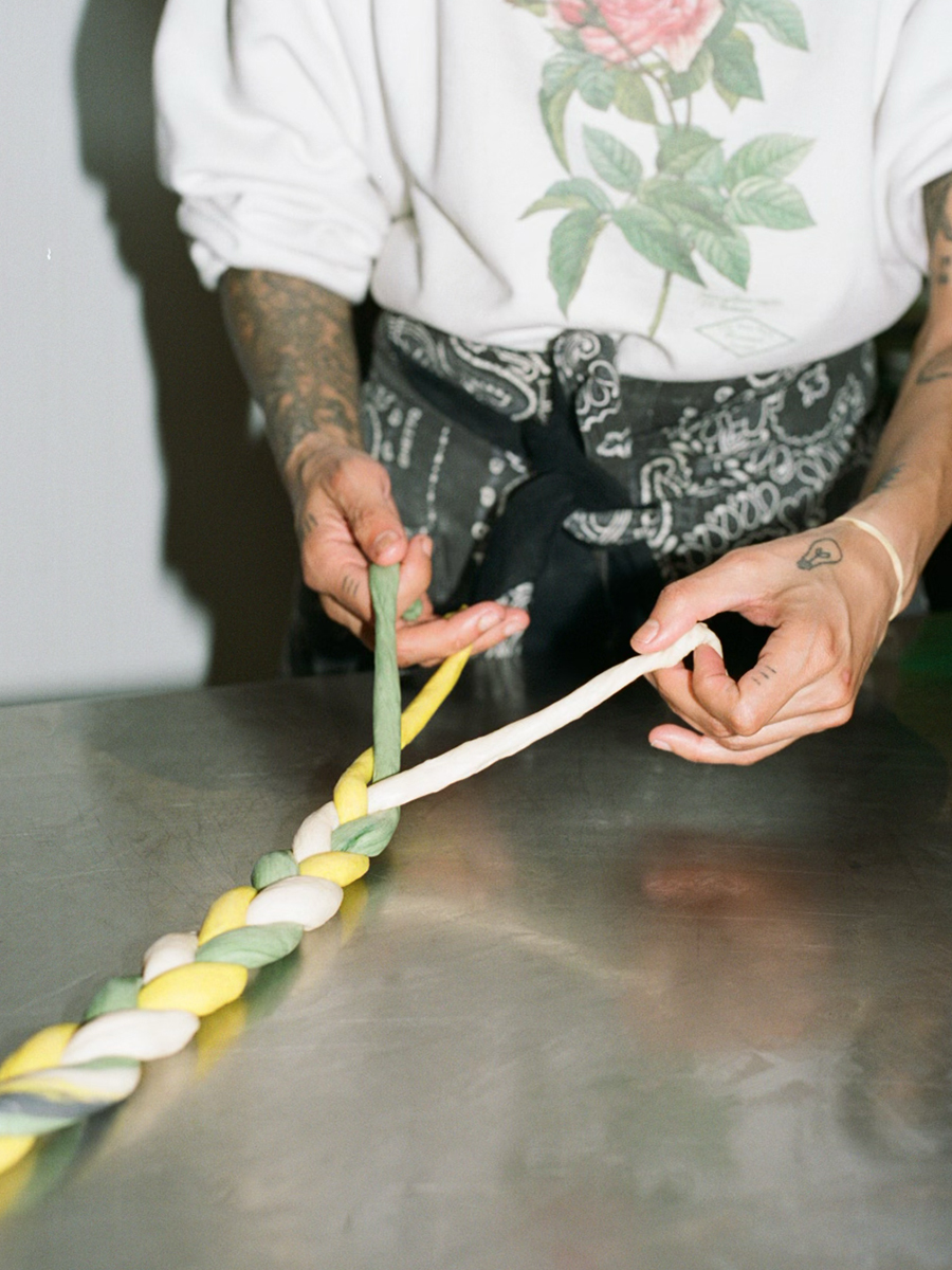 Chef braiding a strand of bread dough.