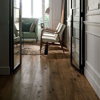 living room wood floor ideas, living room with wood effect porcelain floor, matching armchairs, rug, pale green sofa, floor lamp