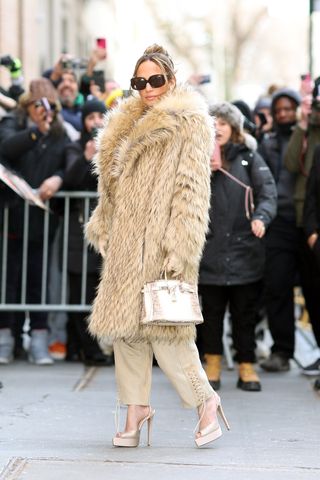 Jennifer Lopez wearing a fur coat in new york city with her himaylayan birkin bag