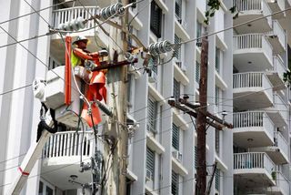 Workmen repair utiliity poles in San Juan, Puerto Rico, after Hurricane Fiona
