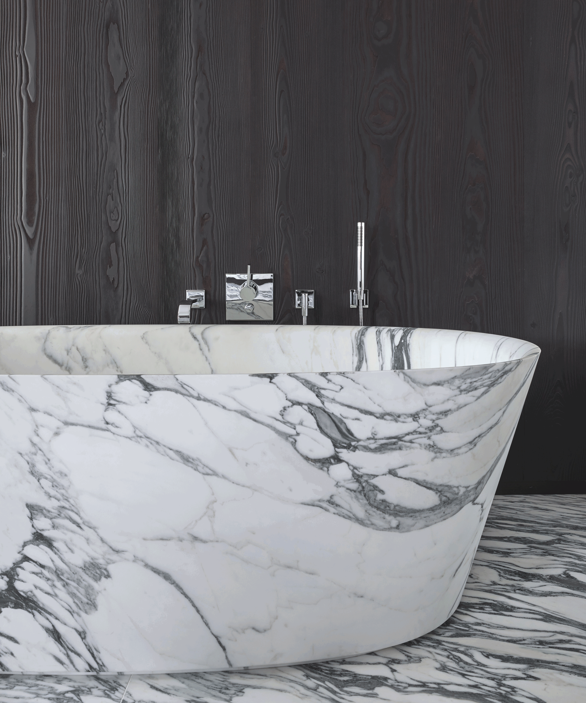 white marble bath against dark wood panelled wall