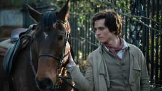 Pip (Fionn Whitehead) petting a horse in Great Expectations.