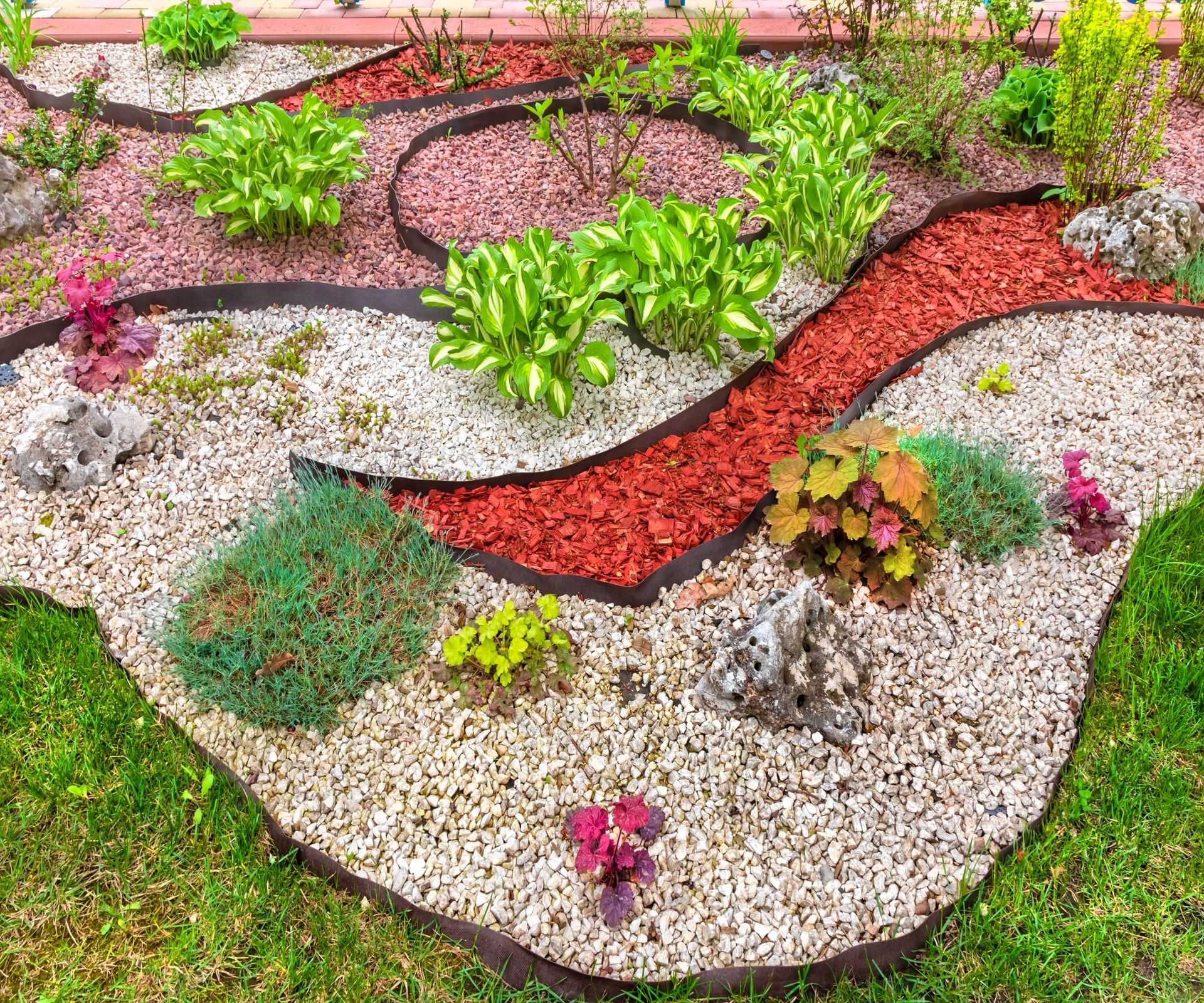 Coloured gravel used as a mulch to create an attractive border pattern