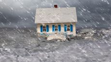 A miniature house partially submerged in turbulent water under a stormy sky and heavy rain