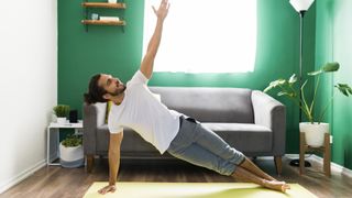Man doing side plank exercise at home