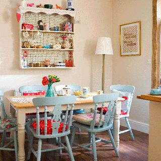 dining area with table mix of patterned cushion pads to brighten up the pastel chairs