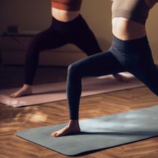 A woman doing unilateral exercises on a yoga mat in a studio