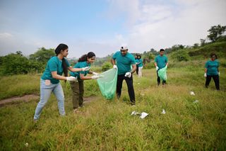 Volunteers pick up trash in a field