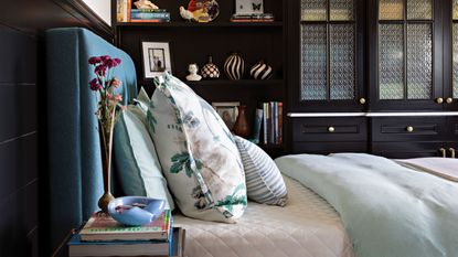 Small guest bedroom ideas are useful to have in mind. Here is a blue bed with a white mattress in a bedroom with dark brown shelving units and nightstand