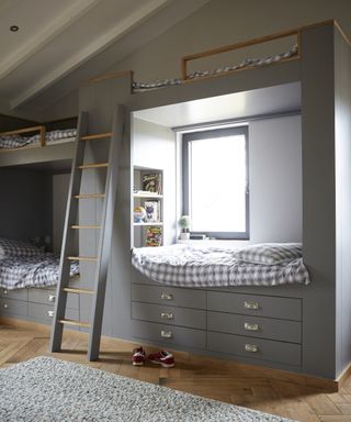 A kids bedroom with two double bunk loft beds painted grey