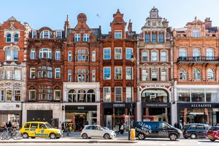 R7T305 London, UK - September 13, 2018: Neighborhood district of Knightsbridge brick architecture, road, cars in street traffic on sunny day