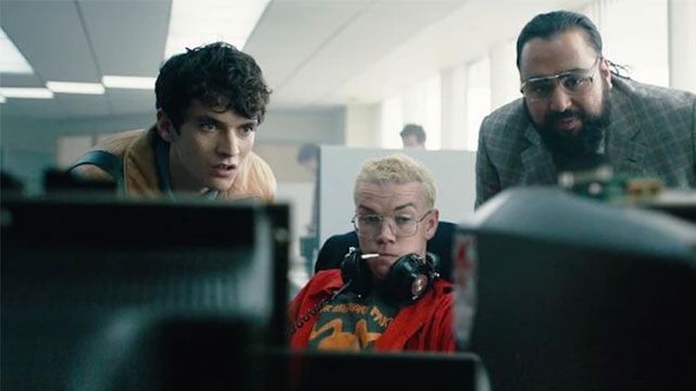 Colin, Stefan and Mohan look at a computer screen in Black Mirror: Bandersnatch.