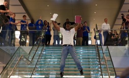 Apple staff members cheer the first customer to purchase the iPad 2 last year: The iPad 3 is set to be unveiled in San Francisco on Wednesday.
