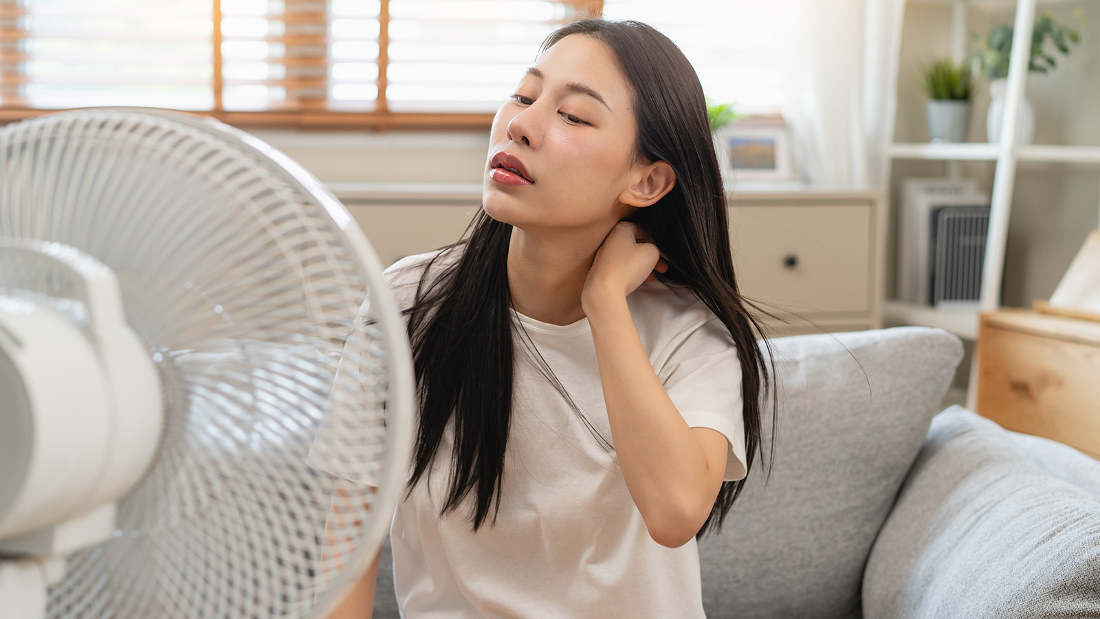 Woman sat in front of a cooling fan