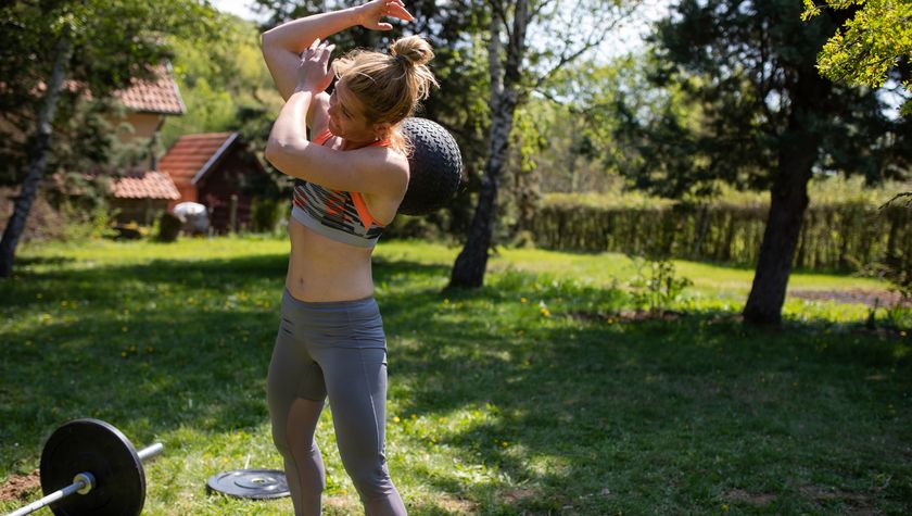 Woman performing D-ball over shoulder outside