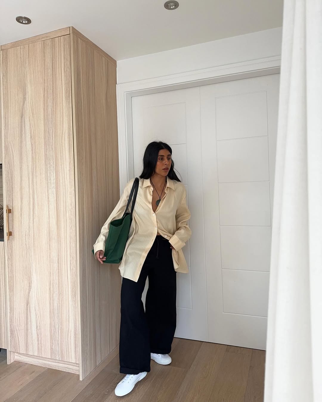 Monikh in black flare jeans and a light neutral top