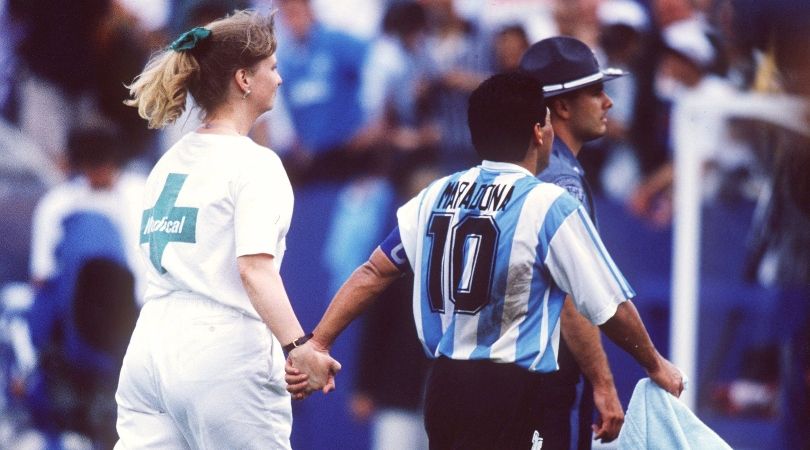 Diego Maradona holds hands with a nurse as he is led away for a drugs test following Argentina&#039;s game against Nigeria at the 1994 World Cup.