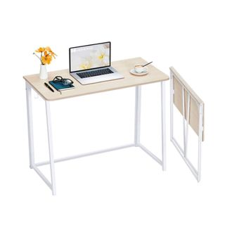 A white desk with a laptop and decorations on it
