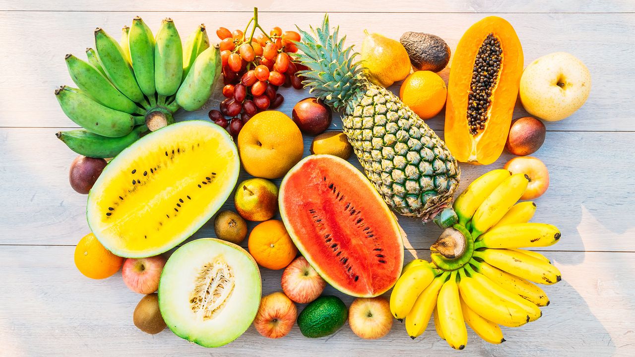 Selection of fruits, including bananas, pineapple, watermelon and grapes, illustrating the question &#039;is fruit healthy?&#039;