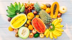 Selection of fruits, including bananas, pineapple, watermelon and grapes, illustrating the question 'is fruit healthy?'