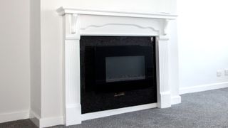 White painted fireplace surround with white painted walls