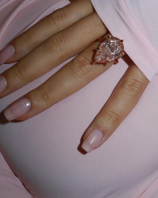 Christian Serratos wearing a pink diamond engagement ring with a red enamel band.