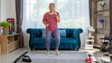 senior woman walks on the spot doing an at-home walking workout