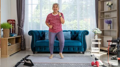 senior woman walks on the spot doing an at-home walking workout