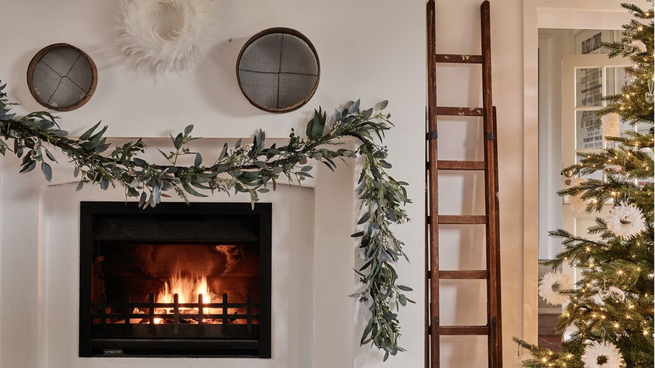 Minimalist Christmas fireplace idea with garland by The White Company