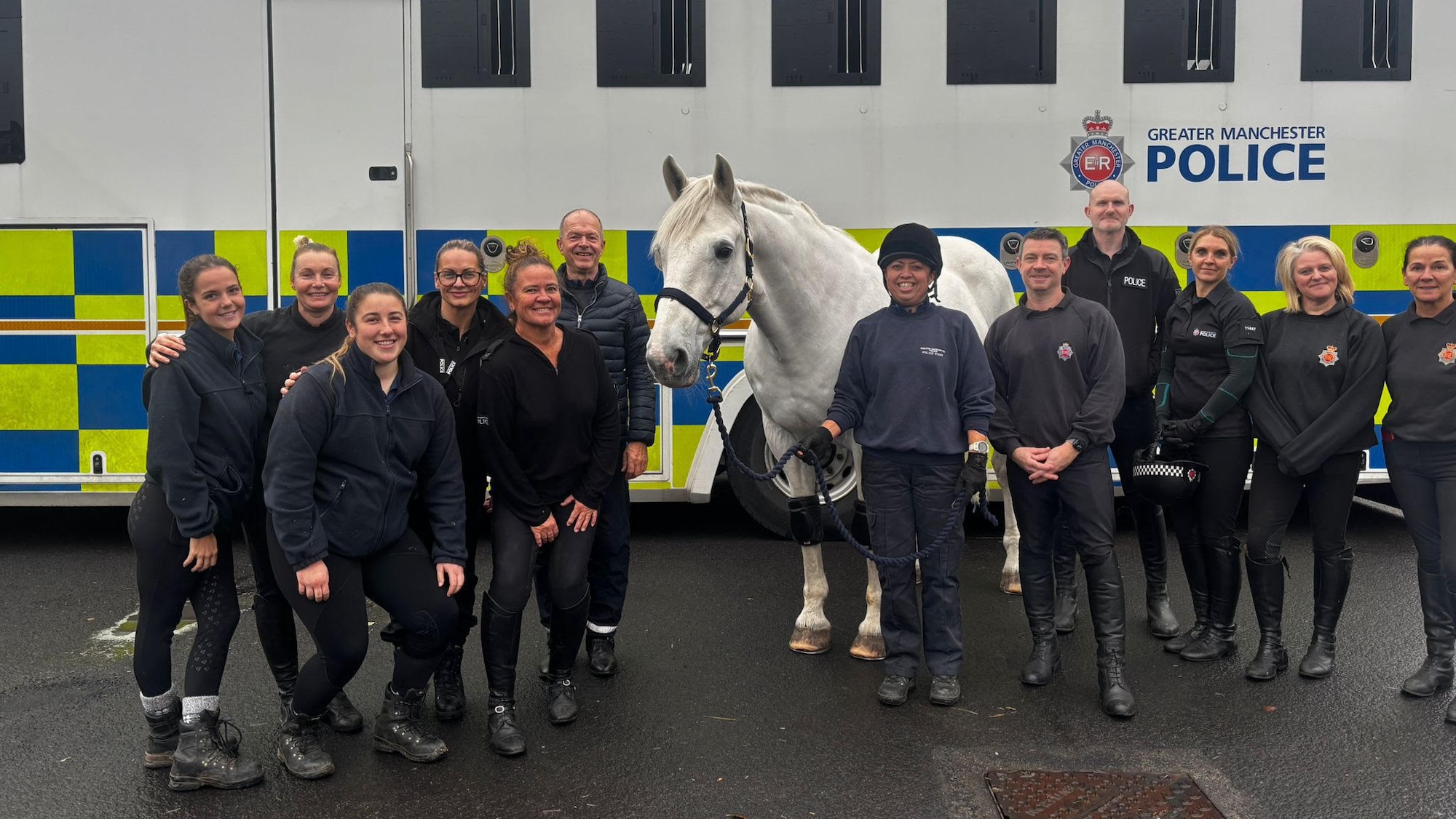 Police Horse Hexam stands in front of the police horse lorry with his human colleagues.