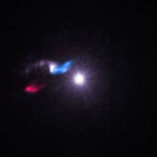 a few blurry splotches of white, red and blue light in the black of space.