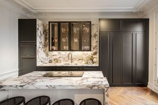 a black and marble kitchen in a parisian apartment