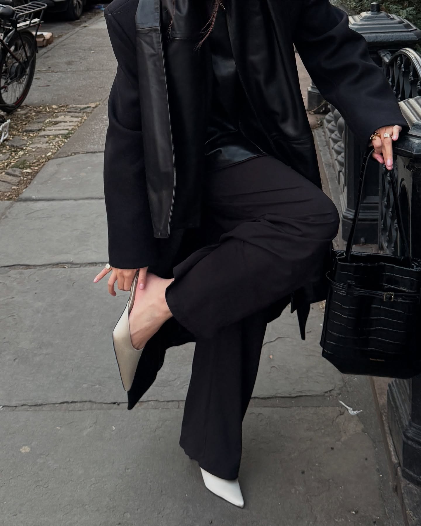 Influencer @mimixn wears white satin kitten heels with black satin trousers and a black leather jacket.