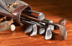 Golf Clubs in a caddy lying on a wooden floor