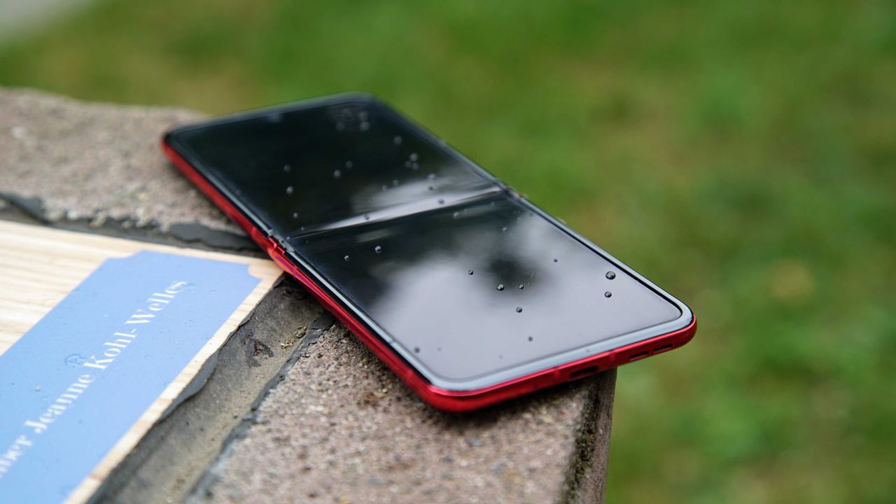 The Motorola Razr+ lying flat with raindrops on the display