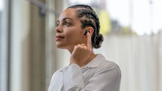 Woman wearing Sony WF-1000XM5 wireless earbuds.