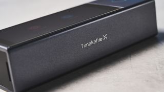 A black and gray Timekettle X1 AI Interpreter Hub translator