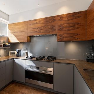 Inside the kitchen of Farnell Mews with wooden and grey cabinets and gas stove