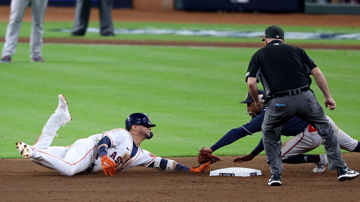 Yuli Gurriel #10 of the Houston Astros is tagged out at second base by Ozzie Albies #1 of the Atlanta Braves after trying to turn a single into a double during the eighth inning in game one of the World Series at Minute Maid Park on Oct. 26, 2021 in Houston, Texas.