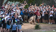 Cameron Smith hits a shot surrounded by golf fans