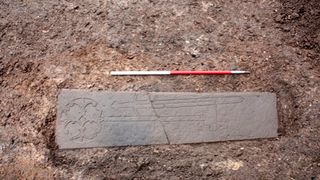 This carved slab, thought to be the headstone of a medieval knight, was found under a parking lot in Edinburgh. Now researchers say they have unearthed what may be the knight's family.