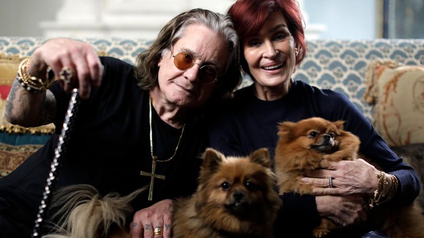 Ozzy Osbourne and Sharon Osbourne on a sofa, holding two dogs