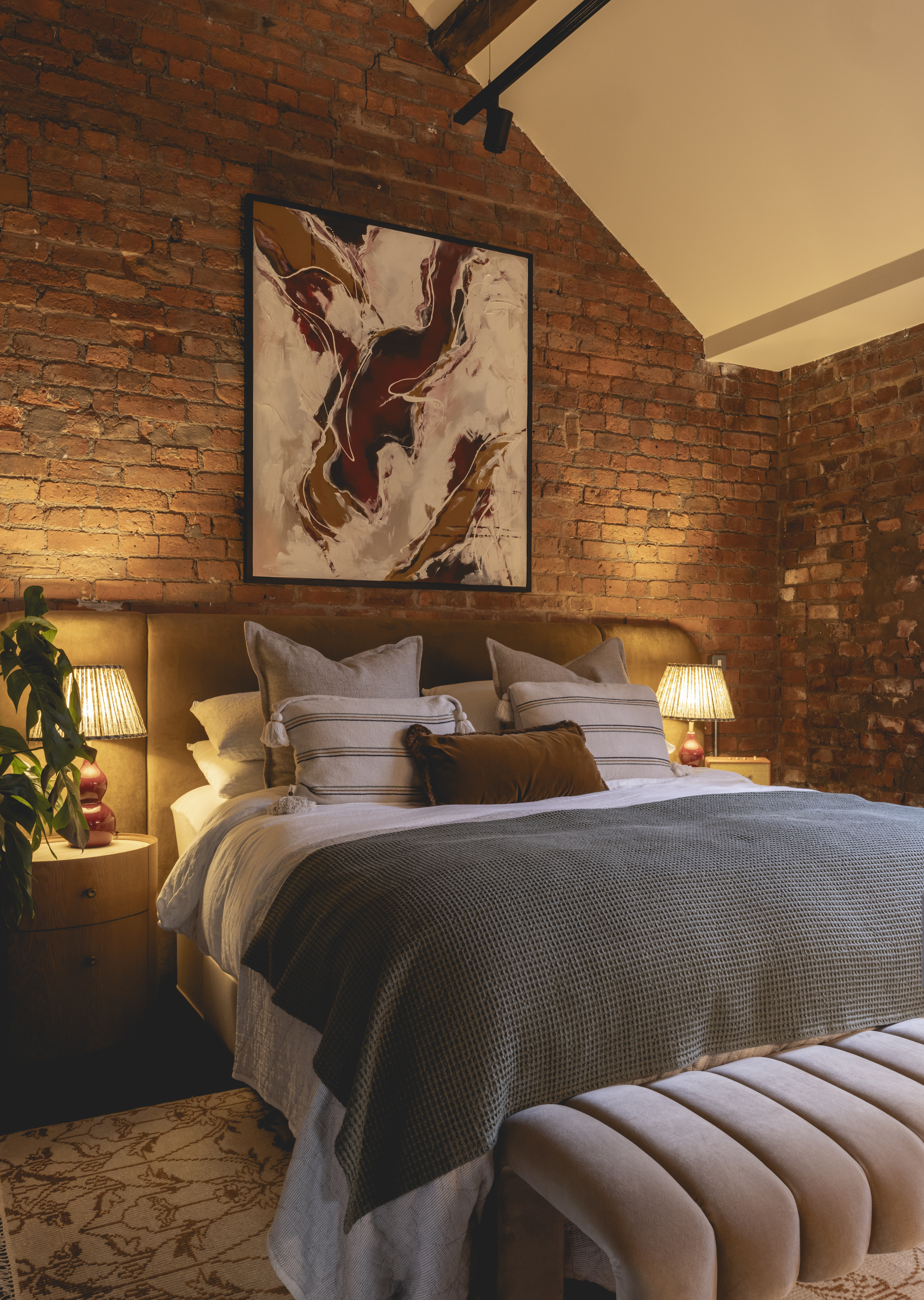 A contemporary bedroom with rustic exposed brick walls