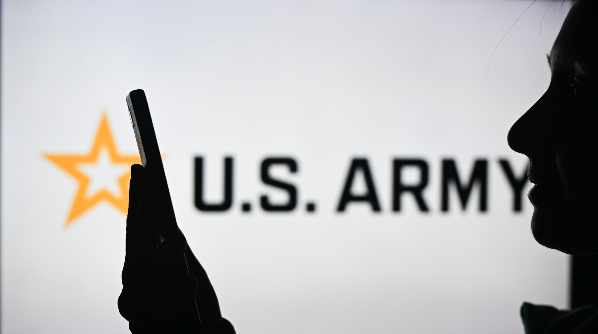 EDMONTON, CANADA - APRIL 28: An image of a woman holding a cell phone in front of a U.S. Army logo displayed on a computer screen, on April 29, 2024, in Edmonton, Canada. 