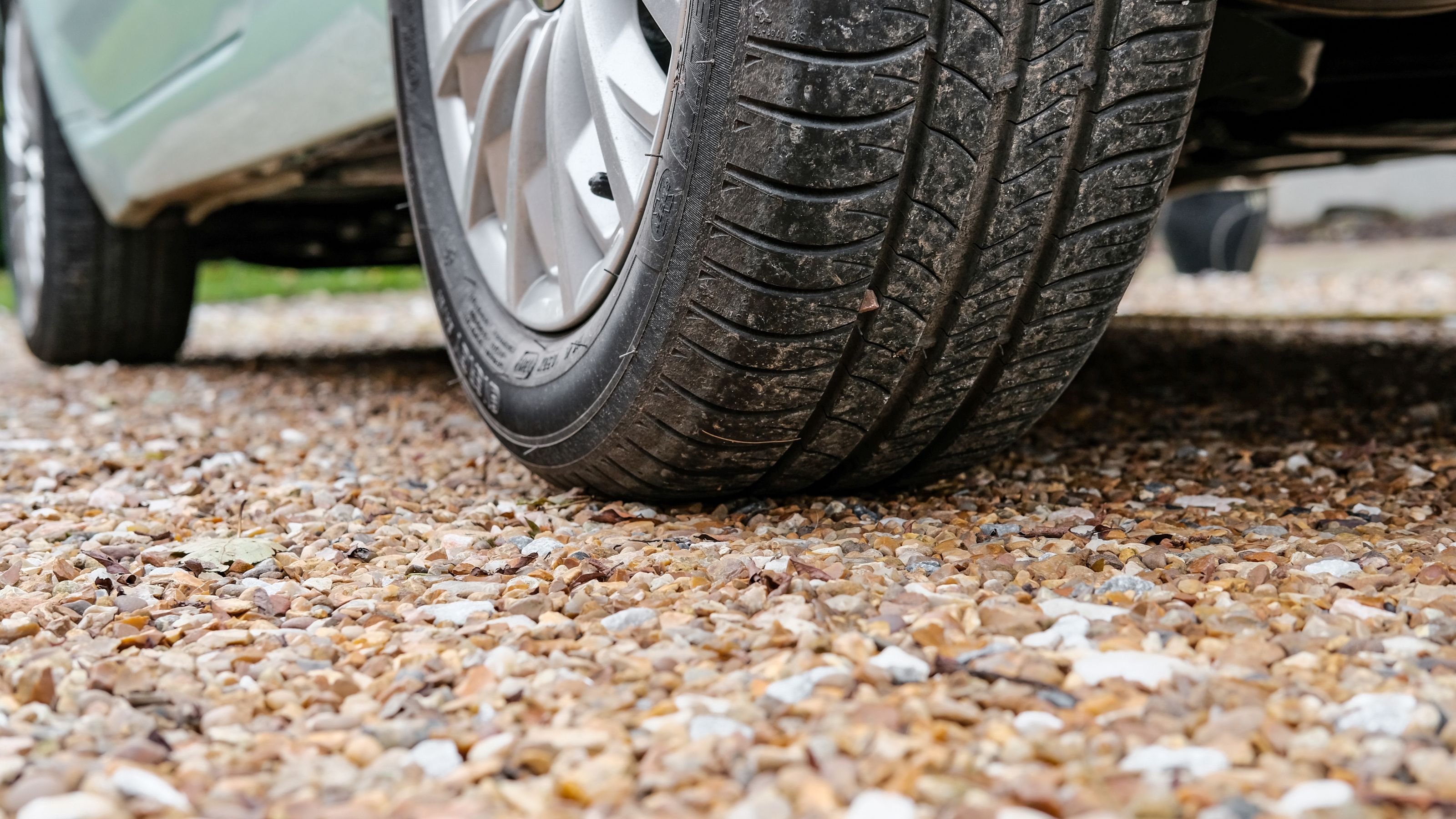Close up of car wheel on gravel driveway