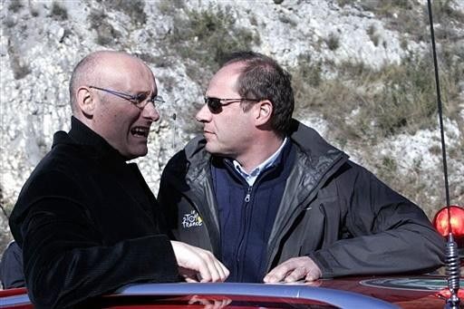 France's Secretary of State for Sport, Bernard Laporte, rides along with Christian Prudhomme (r) of the Amaury Sport Organisation (ASO) during the Paris-Nice.