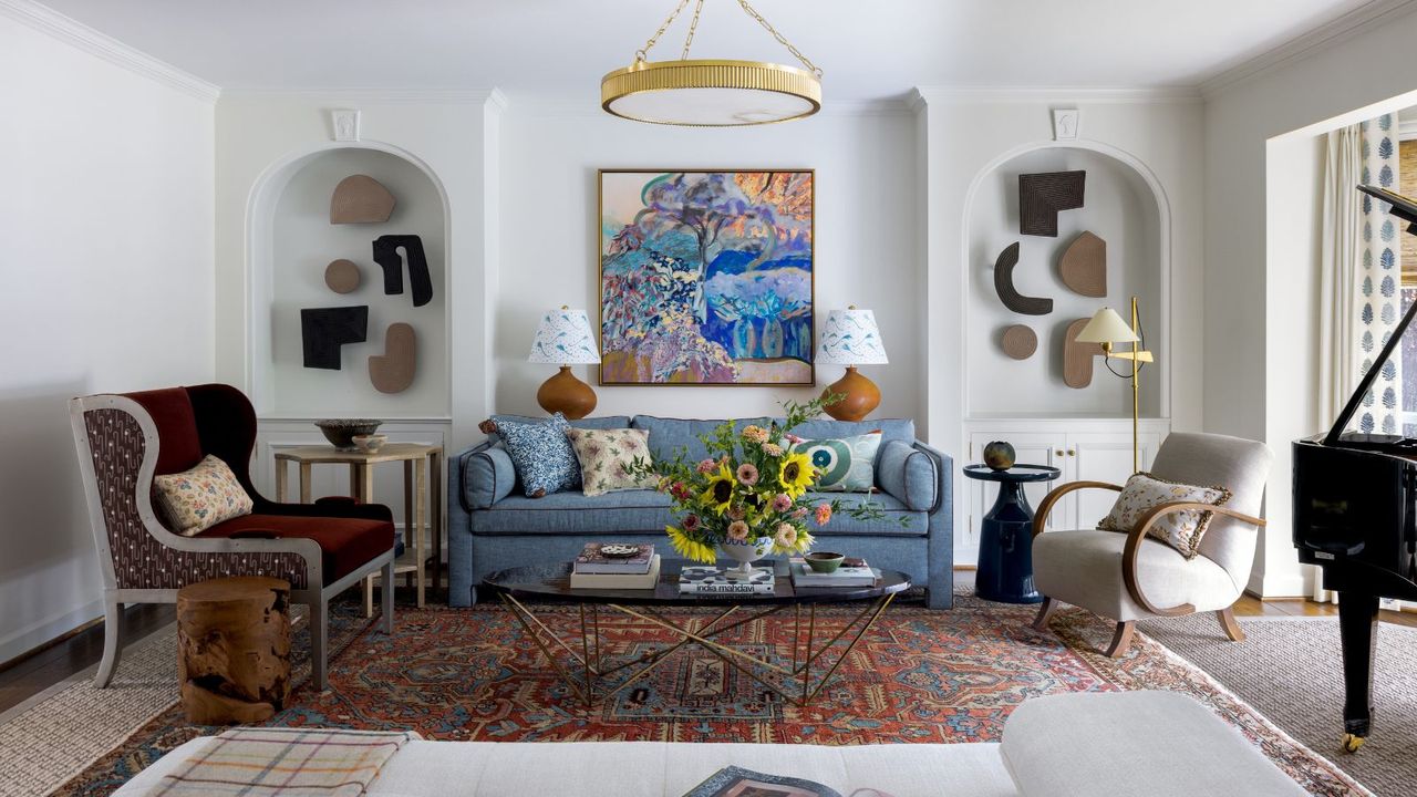  living room with white walls blue sofa and sculptures