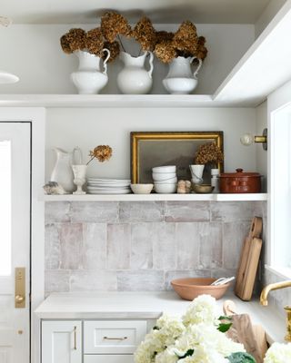 A kitchen corner with fall flowers displayed in large vases