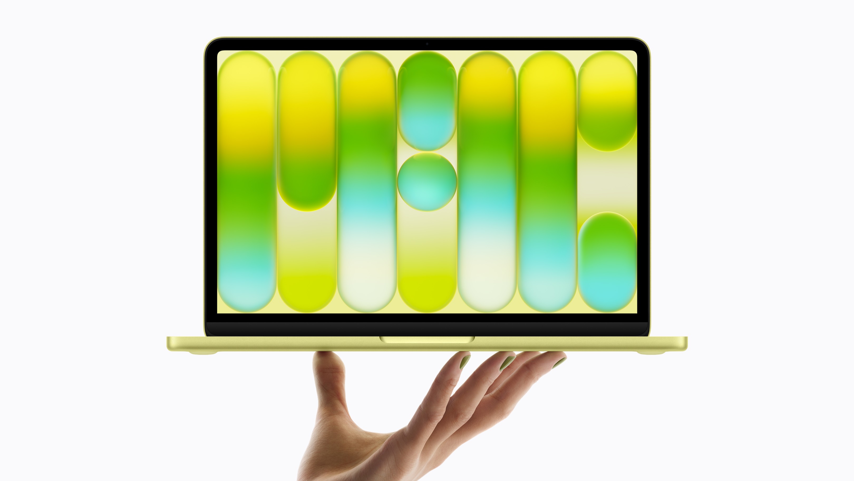 A hand holding a yellow MacBook Neo on a white background