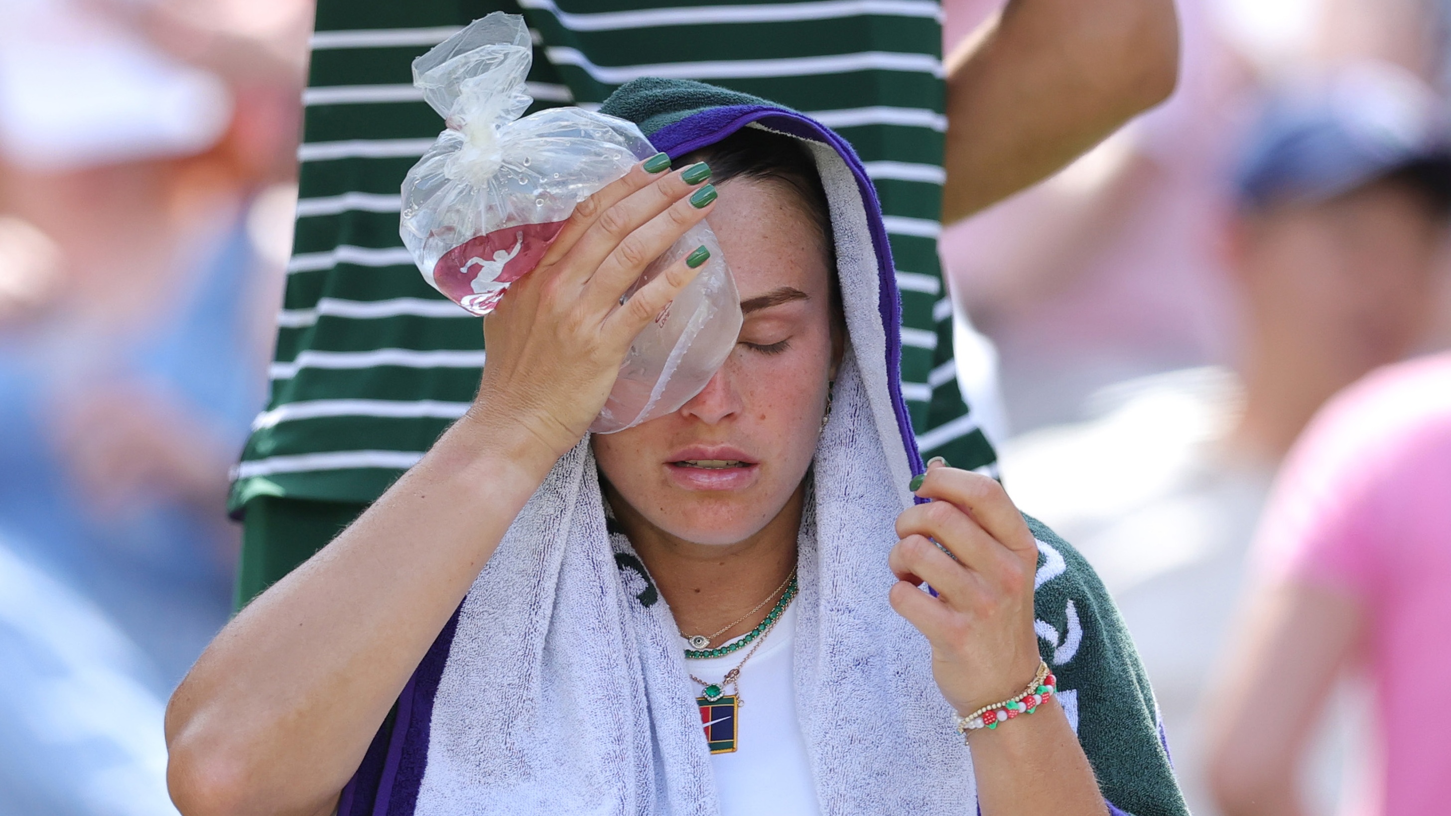 Aryna Sabalenka holding an icepack too her head.